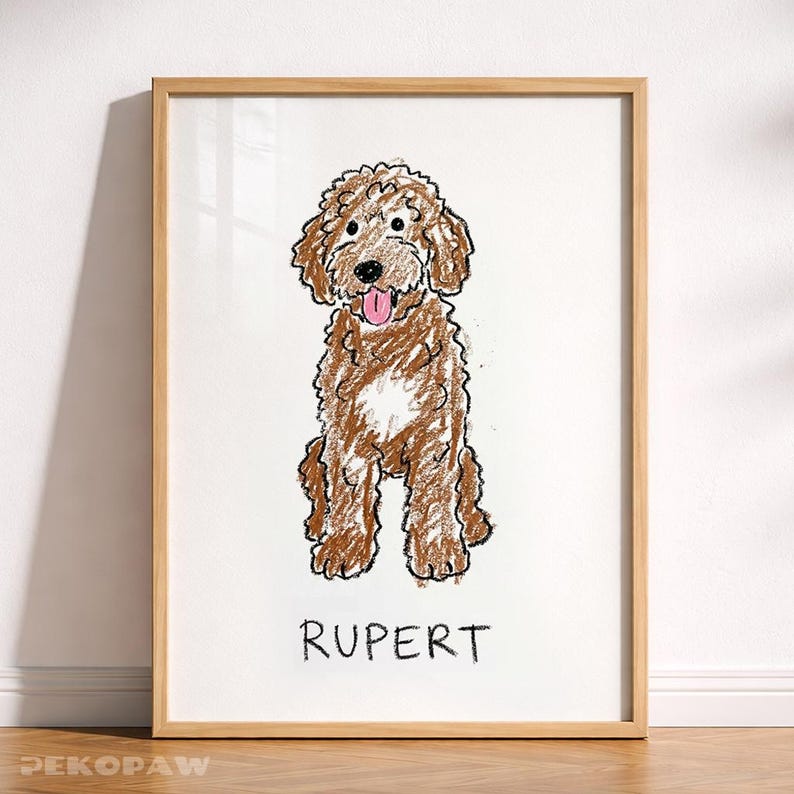 Puede incluir: Una obra de arte enmarcada con una ilustraci&oacute;n de un perro doodle marr&oacute;n. El perro est&aacute; representado sentado con la lengua fuera, dibujado con un estilo de cray&oacute;n. El nombre "RUPERT" est&aacute; escrito debajo. La obra est&aacute; en un marco de madera.
