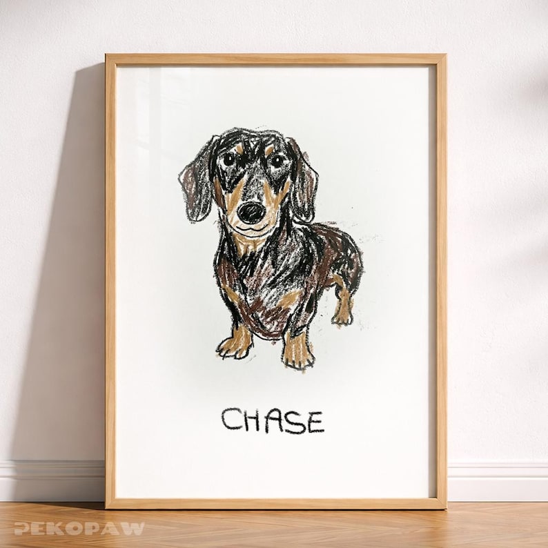 Puede incluir: Una impresi&oacute;n art&iacute;stica enmarcada con una ilustraci&oacute;n de un perro salchicha. El perro est&aacute; representado con trazos de cray&oacute;n negros, marrones y beige. El nombre "CHASE" est&aacute; escrito debajo. El marco es de madera clara.