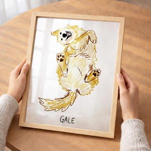 Puede incluir: Dibujo enmarcado de un perro golden retriever en una pose juguetona, con el nombre "GALE" escrito debajo. La obra de arte est&aacute; en tonos amarillos y marrones, enmarcada en madera clara.