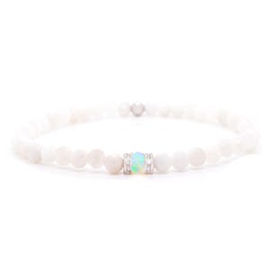 Könnte beinhalten: Weißes Perlenarmband mit einem silberfarbenen Mittelstück mit einem bunten, opalartigen Stein. Das Armband ist mit kleinen, runden, weißen Perlen aufgefädelt. Das Design ist schlicht und elegant, für den Alltag geeignet.