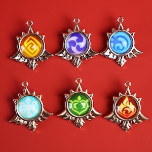 Peut inclure: Six pendentifs métalliques avec des motifs circulaires colorés. Chaque pendentif présente un symbole différent au centre, entouré d'un cadre doré. Le fond est de couleur rouge uni.
