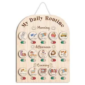Può includere: Una tabella per la routine quotidiana in legno chiaro con un cordino bianco per appenderla. Il pannello riporta il testo My Daily Routine e sezioni per Morning, Afternoon e Evening. Include quindici icone circolari con attività e cursori.