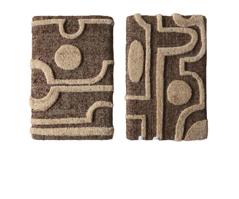 May include: Two rectangular, textured wall hangings with abstract designs. The hangings feature a brown background with beige, raised geometric shapes, including circles and curved lines. The overall aesthetic is modern and artistic.