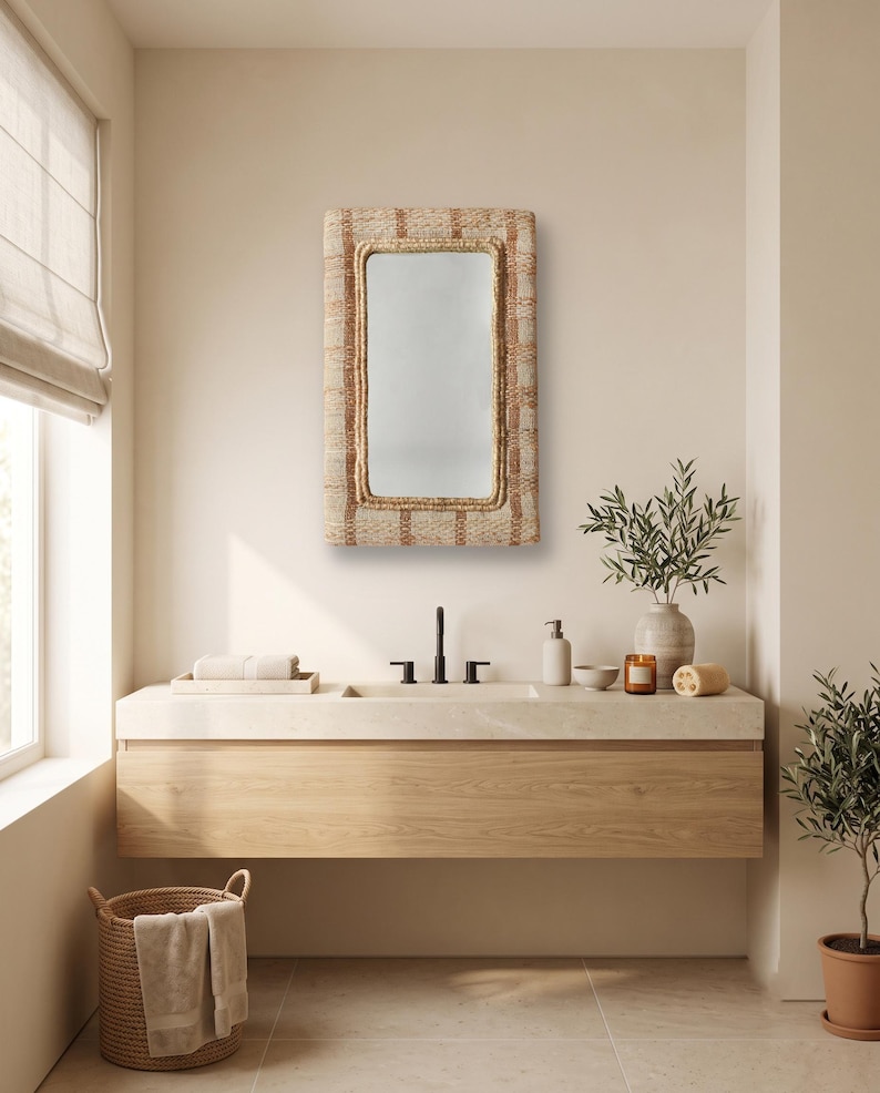 May include: A rectangular wall mirror featuring a textured, woven frame in shades of tan and beige. The mirror has a smooth, reflective glass surface and a thick, braided border that surrounds the central glass pane, mounted on a wall.