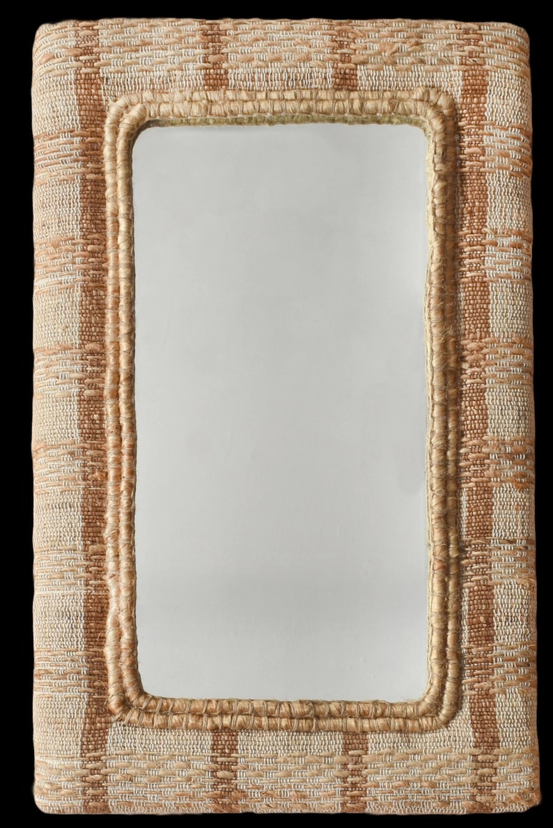 May include: A rectangular wall mirror featuring a thick, textured frame woven from natural fibres in alternating vertical stripes of light beige and tan. The inner edge of the frame is finished with a braided jute trim surrounding the glass surface.