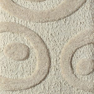 May include: Close-up of a beige bath mat with a textured surface and raised, swirling patterns in a lighter beige color. The design features large, rounded shapes, creating a soft and inviting aesthetic. This bathroom accessory adds a touch of elegance.