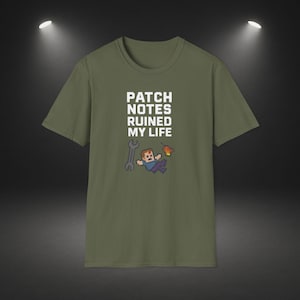 Op de afbeelding: Olijfgroen T-shirt met de witte tekst "PATCH NOTES RUINED MY LIFE". Het shirt heeft een gepixelde afbeelding van een persoon, een moersleutel en een vlam. Een casual kledingstuk.