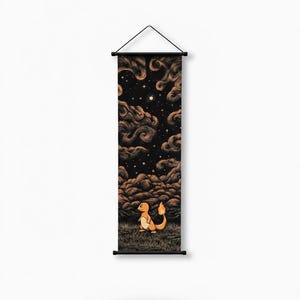 May include: Vertical wall art featuring a Charmander character standing in a grassy field, gazing at a night sky filled with swirling brown clouds, stars, and a moon. The artwork is printed on a fabric scroll with black rods and a hanging string.