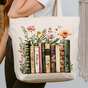 May include: Cream-colored tote bag featuring a watercolor design of colorful flowers and vintage books. The books are in various colors and styles, with floral accents. The bag has sturdy handles for carrying.