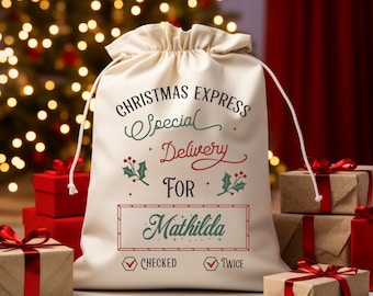 May include: A cream-colored Christmas gift bag with a drawstring closure. The bag features the text "Christmas Express Special Delivery For Mathilda" in various fonts and colors, along with holly illustrations. The bag is surrounded by wrapped gifts.