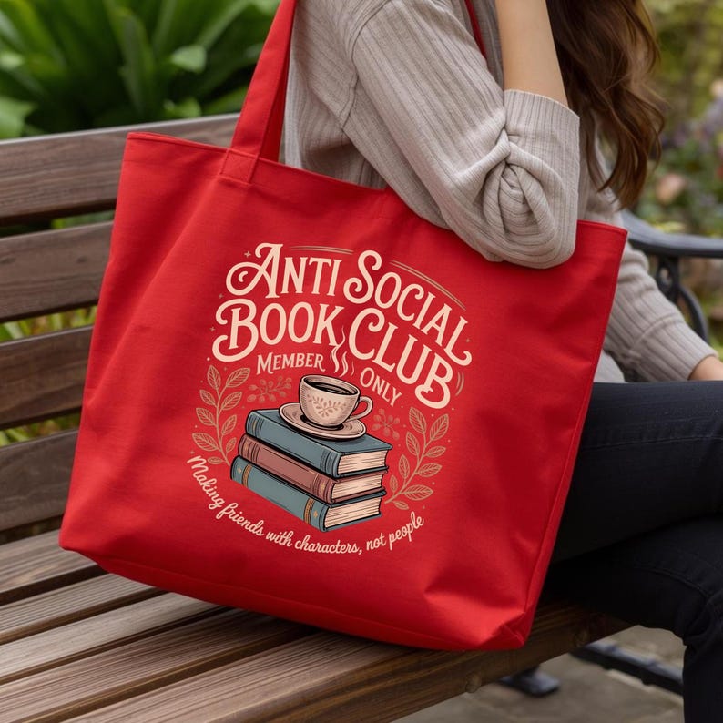 May include: A red tote bag with the text "Anti Social Book Club Member Only" in a vintage style. The design includes a stack of books, a coffee cup, and the phrase "Making friends with characters, not people."