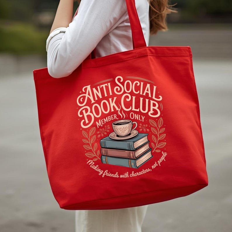 May include: A red tote bag with the text "Anti Social Book Club Member Only" in a decorative font. The bag features an illustration of books and a coffee cup. The phrase "Making friends with characters, not people" is also printed on the bag.