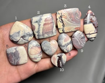 May include: A collection of polished gemstones in various shapes, including teardrop, square, oval, and heart. The stones display a mix of colors, such as cream, gray, and burgundy, with unique veining patterns. The image is labeled with the text "C15".