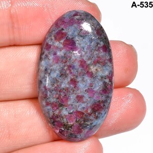 Pode incluir: Uma pedra preciosa oval com uma mistura de cores. A pedra apresenta uma base azul clara com manchas rosa escuro e roxas. O texto "A-535" &eacute; vis&iacute;vel no canto superior direito.