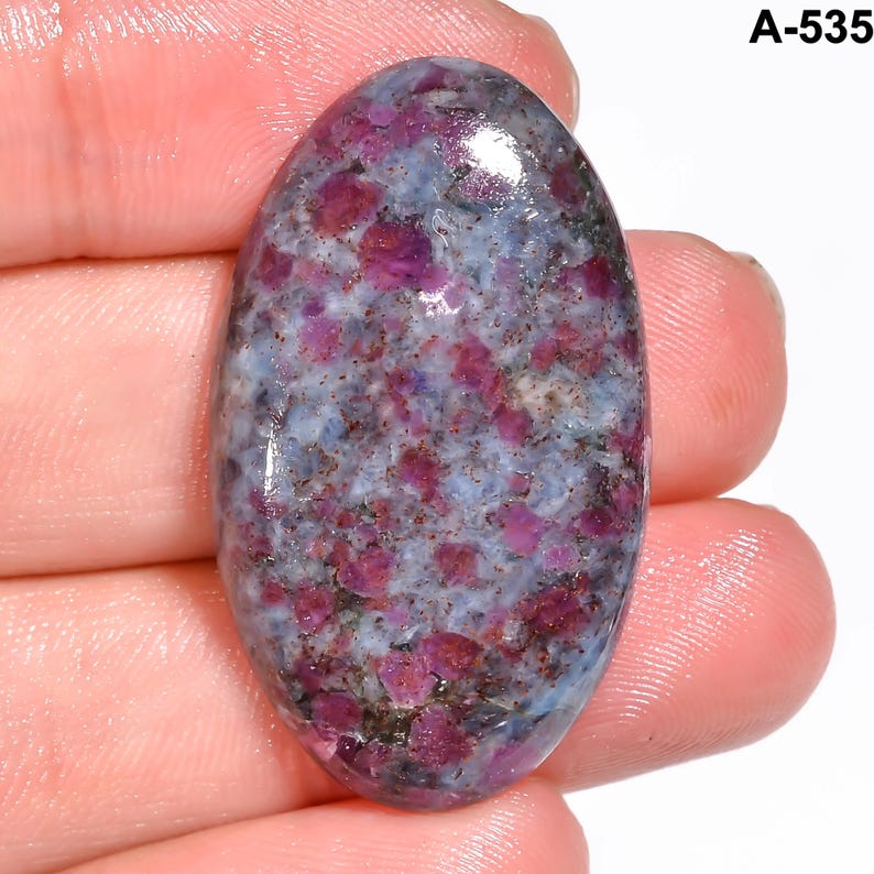 Pode incluir: Uma pedra preciosa oval com uma mistura de cores. A pedra apresenta uma base azul clara com manchas rosa escuro e roxas. O texto "A-535" &eacute; vis&iacute;vel no canto superior direito.