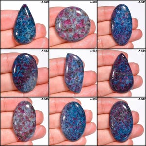 Pode incluir: Nove pedras preciosas polidas em v&aacute;rias formas, incluindo ovais e em forma de gota. As pedras exibem uma mistura de cores azul, vermelho e cinza com padr&otilde;es e texturas &uacute;nicos. Cada pedra tem inclus&otilde;es vis&iacute;veis. A imagem inclui os r&oacute;tulos A-529 a A-537.