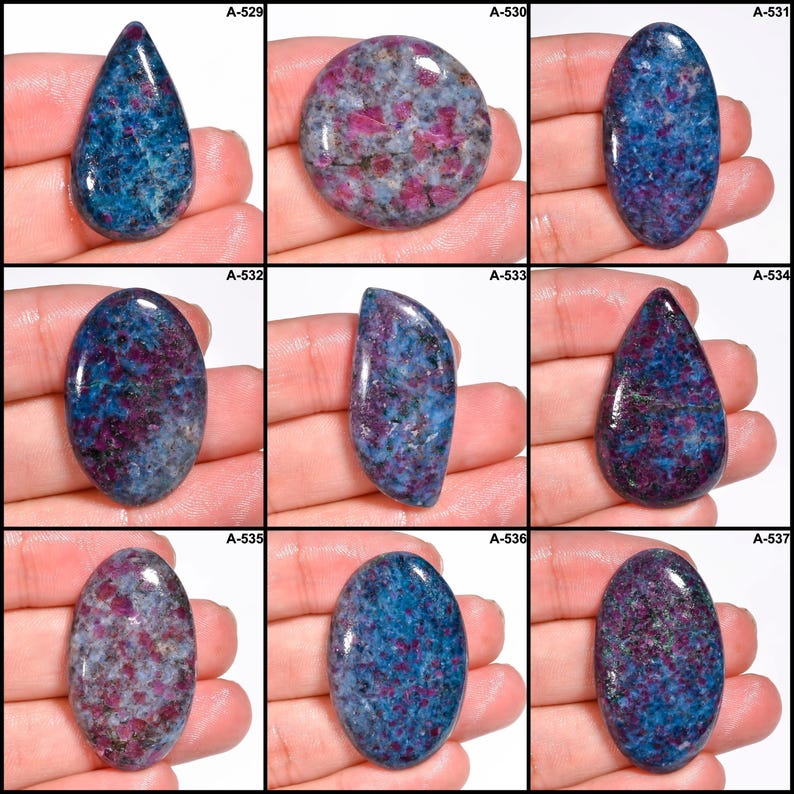 Pode incluir: Nove pedras preciosas polidas em v&aacute;rias formas, incluindo ovais e em forma de gota. As pedras exibem uma mistura de cores azul, vermelho e cinza com padr&otilde;es e texturas &uacute;nicos. Cada pedra tem inclus&otilde;es vis&iacute;veis. A imagem inclui os r&oacute;tulos A-529 a A-537.