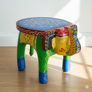May include: A hand-painted wooden elephant stool. The stool features a blue circular top with a floral design. The elephant's head is yellow, red, and black, with green and blue legs. The stool is approximately 12 inches tall.