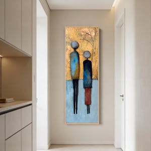 Può includere: Opera d'arte astratta raffigurante due figure stilizzate. L'opera presenta uno sfondo dorato con toni blu e rossi. Le figure sono allungate con forme semplici, creando un'estetica moderna e minimalista.