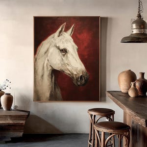 Pu&ograve; includere: Dipinto incorniciato della testa e del collo di un cavallo bianco su sfondo rosso intenso. I lineamenti del cavallo sono dettagliati, con particolare attenzione all'occhio e al muso. L'opera d'arte &egrave; esposta in una stanza con arredi rustici.