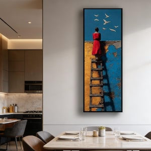 May include: Vertical framed art print showing a person in a red dress on a ladder, gazing at birds in flight against a blue sky. The ladder is against a textured yellow and blue wall.