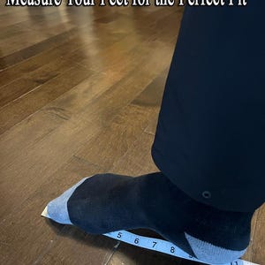 May include: A foot wearing a black and gray sock is being measured with a ruler. The ruler shows measurements in inches. The text "Measure Your Feet for the Perfect Fit" is at the top of the image.