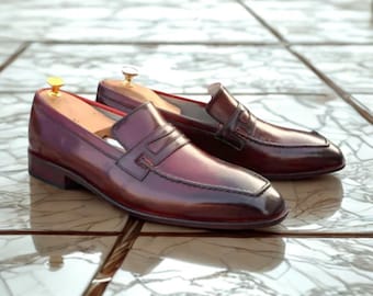 Mocasines de piel burdeos hechos a mano con acabado brillante.