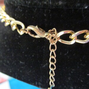 May include: Gold chain necklace with a lobster clasp closure. The chain is made of a thick, chunky link style.