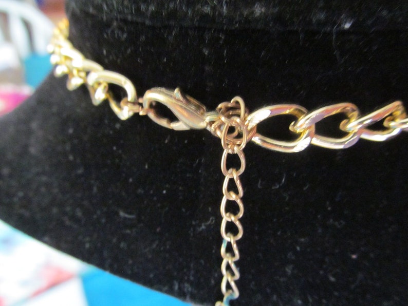 May include: Gold chain necklace with a lobster clasp closure. The chain is made of a thick, chunky link style.