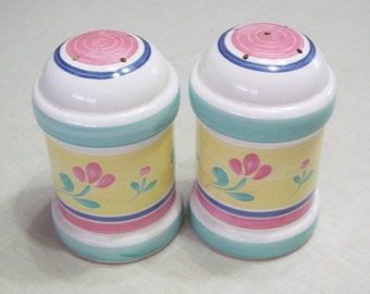 May include: A set of two ceramic salt and pepper shakers with a yellow, pink, blue, and green floral design.