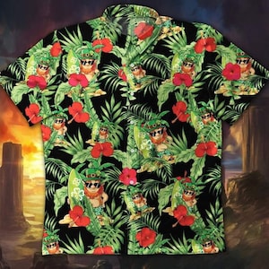 Puede incluir: Camisa negra de manga corta con un estampado tropical. El diseño presenta duendes con tablas de surf, gafas de sol y sombreros verdes, entre flores de hibisco rojas y hojas de palmera verdes. La camisa tiene un cuello clásico.