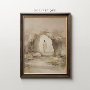 Puede incluir: Impresión artística enmarcada que representa una figura con túnica blanca caminando hacia una abertura en una cueva. La obra de arte tiene una paleta de colores apagados de beige, marrón y gris, con el texto "NOBLESTIQUE" en la parte superior.