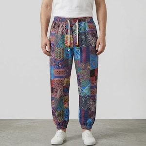May include: Full-length pants featuring a vibrant patchwork design with various colorful patterns including paisley, geometric shapes, and floral motifs. The pants have an elastic waistband with a white drawstring featuring small wooden beads.