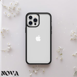 Peut inclure: Coque transparente pour iPhone avec bordure noire. La coque présente le logo Apple et une découpe pour l'appareil photo. La marque "NOVA SHELL DESIGN" est imprimée en bas à gauche. Entourée de fleurs blanches.
