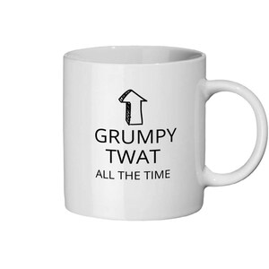 Puede incluir: Taza de cerámica blanca con un gráfico de flecha negra y el texto "GRUMPY TWAT ALL THE TIME". La taza tiene un asa curva y una forma cilíndrica.