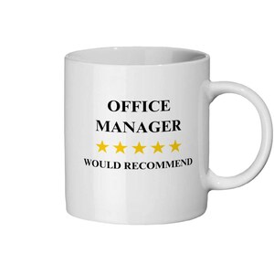 以下が含まれることがあります： 「OFFICE MANAGER」の黒い文字と5つの金色の星、「WOULD RECOMMEND」の文字がプリントされた白いセラミックマグカップ。 マグカップには湾曲したハンドルが付いています。