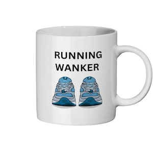 以下が含まれることがあります： 白いセラミックマグカップ。黒字で「RUNNING WANKER」と書かれています。その下に、青とグレーのランニングシューズのグラフィックがあります。マグカップには湾曲したハンドルが付いています。