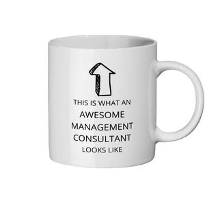 May include: White ceramic mug with a black arrow graphic and the text "THIS IS WHAT AN AWESOME MANAGEMENT CONSULTANT LOOKS LIKE". The mug has a curved handle.