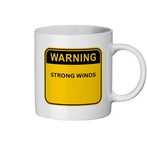 May include: White ceramic mug with a black and yellow warning sign that reads "WARNING STRONG WINDS". The mug has a curved handle and is suitable for hot or cold beverages.