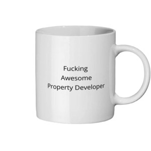 Könnte beinhalten: Weißer Keramikbecher mit dem Text "Fucking Awesome Property Developer" in Schwarz. Der Becher hat einen Standardgriff und eine zylindrische Form, geeignet für heiße oder kalte Getränke.
