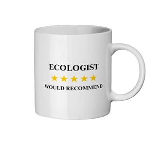 May include: White ceramic mug featuring the text "ECOLOGIST WOULD RECOMMEND" in black, with four gold stars. The mug has a curved handle. The background is plain white.