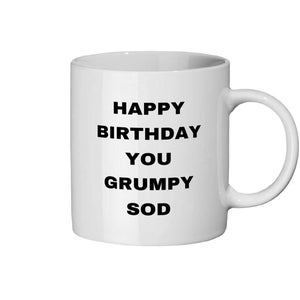 Peut inclure: Mug en céramique blanche avec une anse incurvée. Le mug porte l'inscription "HAPPY BIRTHDAY YOU GRUMPY SOD" en lettres noires grasses, ce qui en fait un cadeau d'anniversaire humoristique.
