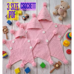 May include: Two pink star-shaped crochet blankets with hoods, each featuring small white flower appliqués and pom-poms at the points. The text 3 SIZE PDF CROCHETT is visible in the upper left corner, surrounded by various colourful wooden toys.