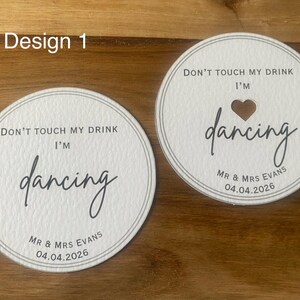May include: A white ceramic mug with a black handle and the text "But First, Coffee" in a black, bold font. The mug is on a white surface.