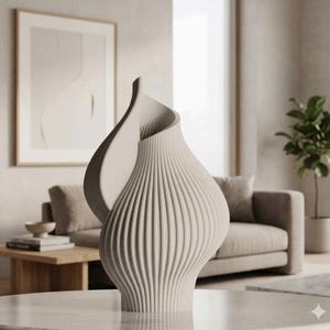 May include: A beige, modern decorative vase with a unique, flowing design. The vase has vertical ribbed detailing and a curved, open top. It is displayed on a marble-like surface, showcasing its sculptural form. The vase is a stylish home decor item.