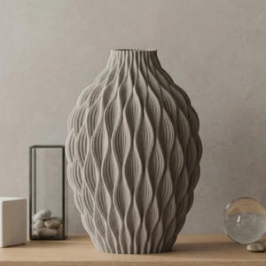May include: A set of three ceramic mugs with a speckled, matte finish. The mugs are in shades of cream, light gray, and dark gray. Each mug has a simple, minimalist design and a rounded handle.
