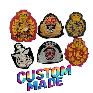 Op de afbeelding: Een verzameling geborduurde patches in verschillende vormen en kleuren. De patches hebben gouden en zilveren draaddetails, kronen, ankers en tekst. De patches zijn rood, zwart en marineblauw. De tekst "CUSTOM MADE" staat onderaan.