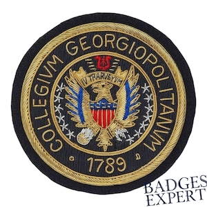 May include: A round, embroidered patch with the text "COLLEGIUM GEORGIO POLITANUM" in gold thread. The patch features a central emblem with an eagle, red and blue accents, and the year 1789. The patch is on a black background.