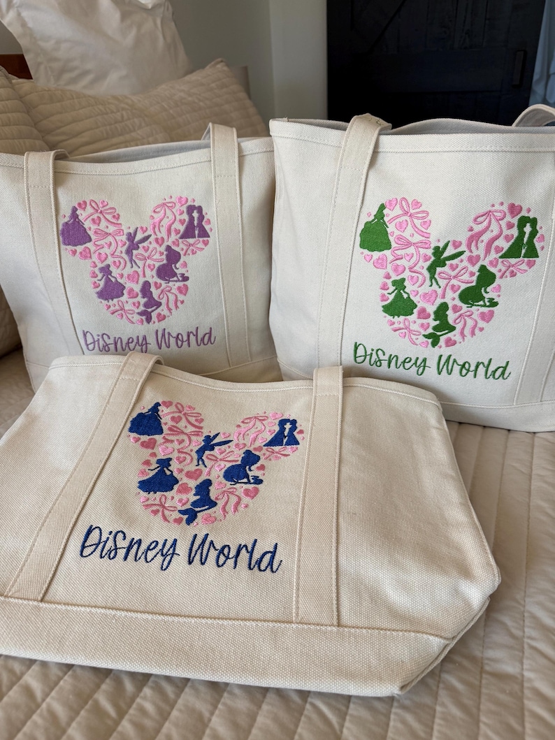 May include: Three canvas tote bags with embroidered Disney World designs. Each bag features a Mickey Mouse head shape filled with silhouettes of characters and hearts. The text "Disney World" is embroidered below the design in various colors.