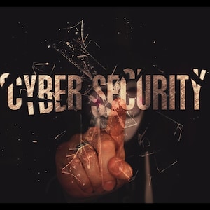 May include: A dark image with the words "CYBER SECURITY" in a distressed, golden font. A hand is pointing towards the text, with a shattered glass effect overlaying the image, suggesting a breach or vulnerability in digital security.